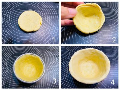 酥皮壓扁，用雙手拇指由酥皮中心往外推壓，讓中心薄而外圈厚。再放入蛋撻杯中，由下往上沿著杯緣推擠壓薄，一直推倒杯子最外緣處，因為蛋撻皮在烤的時候會略微內縮，所以這個動作一定要確實做到，避免內縮後蛋撻液外流