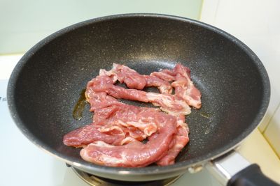 平底鍋內放入麻油，熱鍋後放入用蜂蜜醃好的豬肉片，用中火炒。