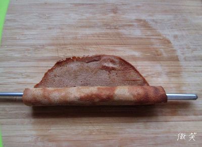 馬上取出餅皮,要趁還是有溫度的時後以鐵筷子捲成細長的圓桶,並且捲的速度要快一些,如果餅皮涼了就會很難捲起也容易捲碎,稍微定型時再抽出筷子.