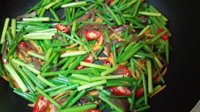 下黑木耳、韭菜花段、辣椒，拌炒30秒，加100cc熱水，滾煮一分鐘。
