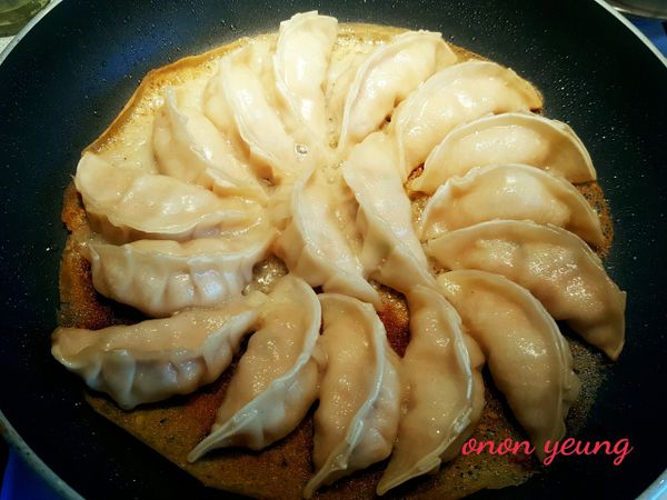 下鍋把餃子煎至微黃色，倒入麵粉水蓋上鍋蓋用中火煎至麵粉脆皮呈金黃色，淋上麻油（可省略）即行。