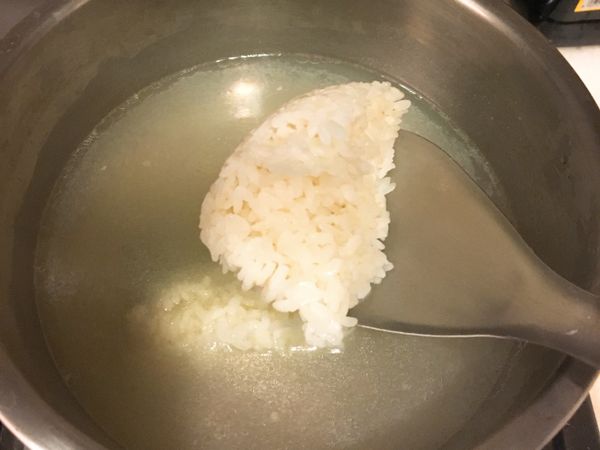 煮完的蛤蜊水與高湯混合，放入兩人份的白飯拌煮