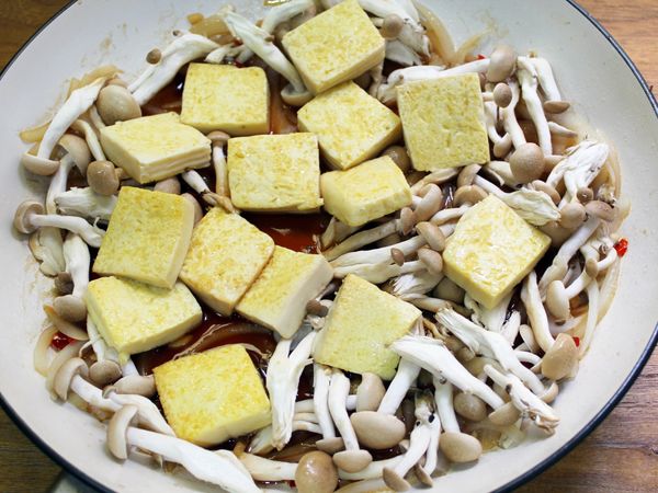 倒回豆腐及鴻喜菇, 蓋上鍋蓋悶煮至鴻喜菇熟透