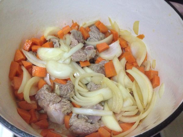 加入牛肉及馬鈴薯拌炒，隨即入番茄調味，加入兩大碗水燜煮。