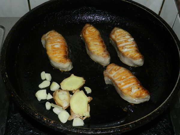 在鍋邊下薑片與蒜末爆香