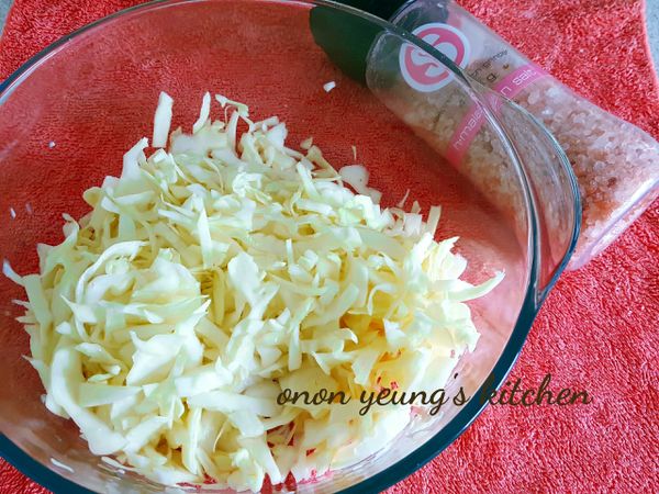 先把高麗菜洗淨後切成絲，加入1茶匙的鹽拌勻靜置 20-30 分鐘，然後沖洗擰乾水份備用。