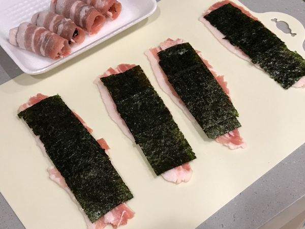 豬肉灑上少許鹽和胡椒，將海苔鋪在肉上，兩端不要蓋滿，緊緊的捲起來。豬肉片若比較薄或不夠寬，可以兩片稍微重疊再捲海苔喔！
