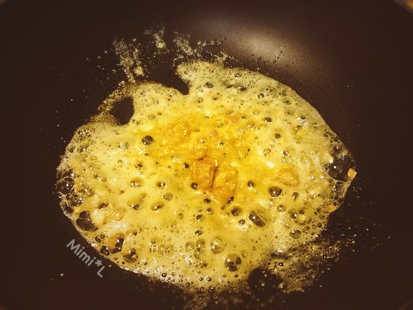 熱油鍋爆香蒜後，將鹹蛋黃炒至起泡