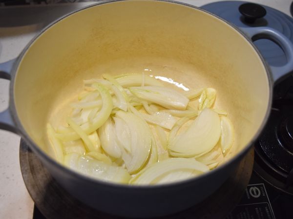 鍋中放入適量橄欖油，將洋蔥絲及蒜片放入鍋中以小火炒香。