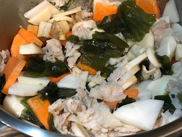鍋中加入少許油，下薑片和豬肉直接拌炒，肉變色後，依序加入海帶芽、白蘿蔔、紅蘿蔔、和杏鮑菇翻炒一下，加入足量的水煮滾，除去多餘的浮渣，蓋上鍋蓋悶煮10-15分至蘿蔔熟軟。