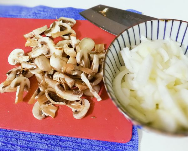 洋菇切片、洋蔥切絲及照片未拍到的蒜頭切末、辣椒切片、九層塔切碎備一旁。