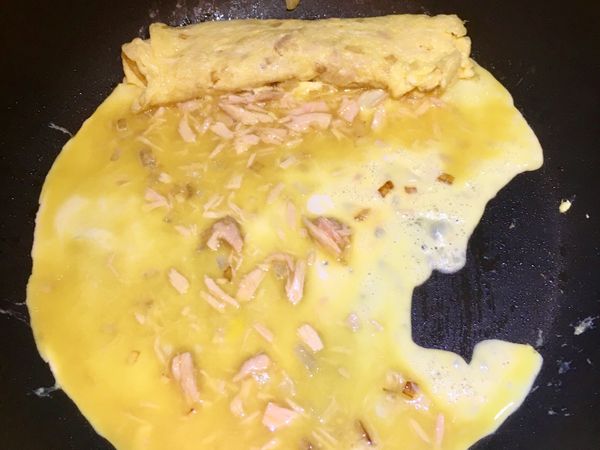 平底鍋開火上油塗勻，加入一勺蛋液在鍋子中間讓它散開，從前面往自己方向捲起玉子燒，捲完後把玉子燒移到鍋子前面，再塗一點油繼續下一勺蛋液，重複同樣的動作到蛋液用完