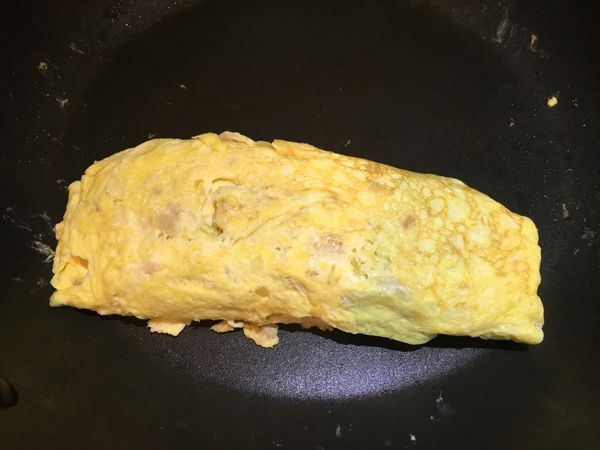 完成玉子燒後，趁熱用廚房紙巾將玉子燒包起來，利用餘熱塑形