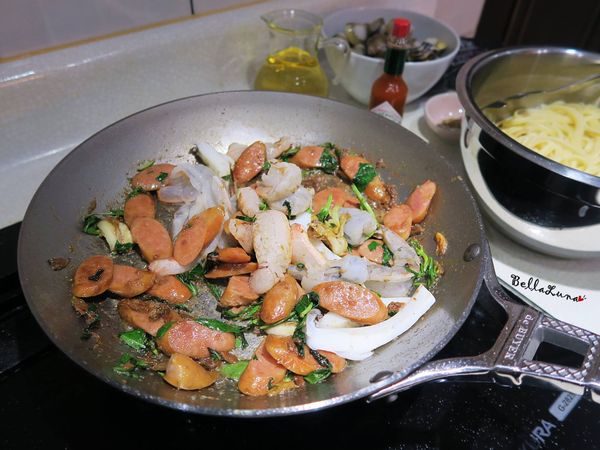 最後放入花枝、蟹棒、蛤蠣拌炒。