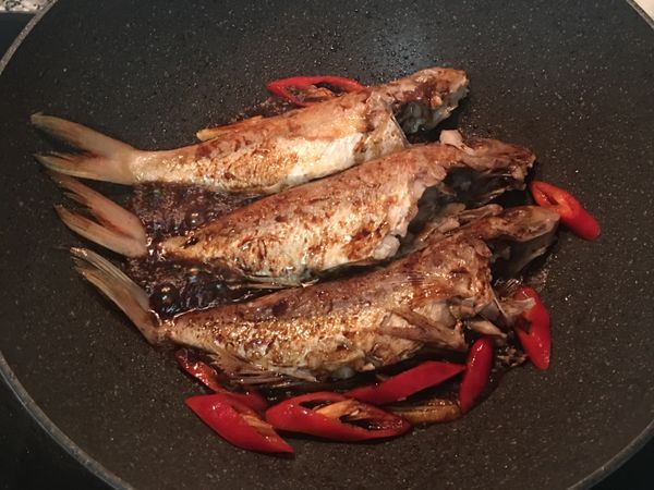 醬油+糖+水混合，延鍋邊倒入熗煮一下，放入辣椒一起燒。