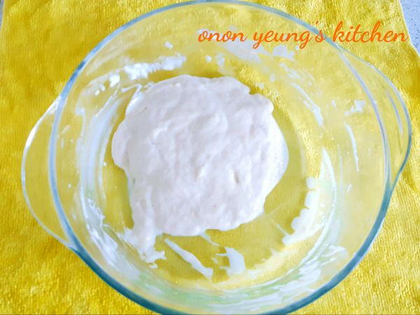 然後，把室溫鮮奶分次加入麵粉糊裡拌勻。