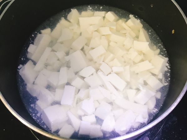 開小火，等水滾了，加入一大匙鹽巴，為了使豆腐更容易入味，將切好的豆腐丁，放入鹽水煮一分鐘。