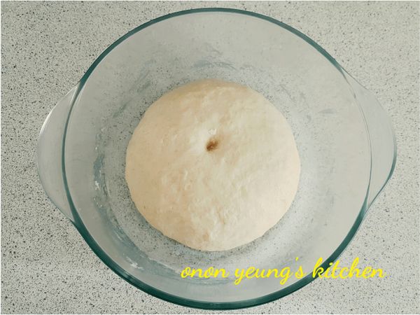 然後，放進底部已經搽上食用油的容器裡發酵半個小時。可以在烤箱裡放一杯熱水，把裝有麵糰的容器放進烤箱進行發酵過程。

用手指沾上粉糰在中間壓下去形成凹槽，沒有回彈表示發酵完成。