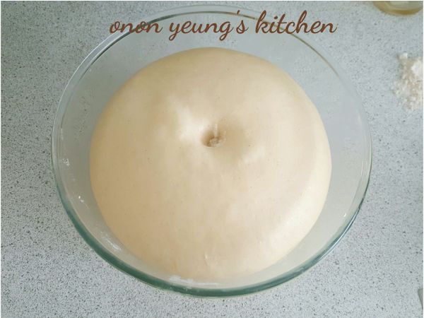 然後，放進底部已經搽上食用油的容器裡發酵一個小時。可以在烤箱裡放一杯熱水，把裝有麵糰（表面灑點水）的容器放進烤箱裡進行發酵過程。

用手指沾上高筋粉在麵糰中間壓下去形成凹槽，沒有回彈表示發酵完成。