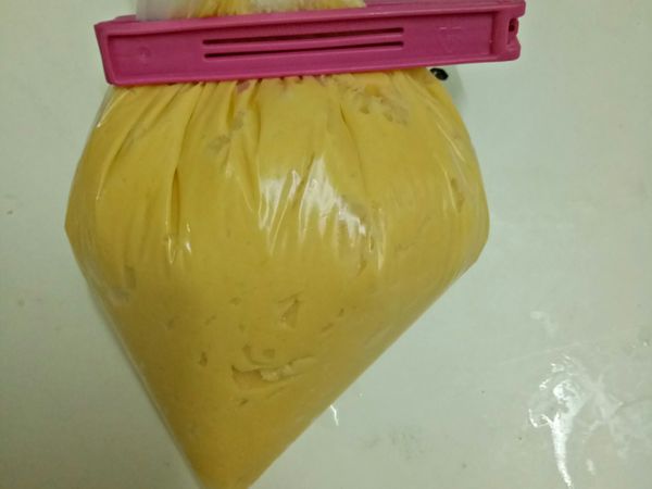 把拌好的材料倒入擠花袋或塑膠袋，我就就地取材，直接用塑膠袋，一樣可以擠唷。