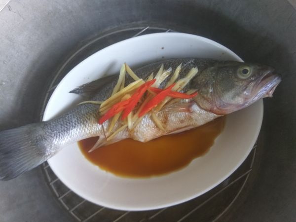 將鱸魚盤放進傳統電鍋中，外鍋加1杯水，蓋上鍋蓋，按下開關進行蒸煮動作，待開關跳起來就好了。