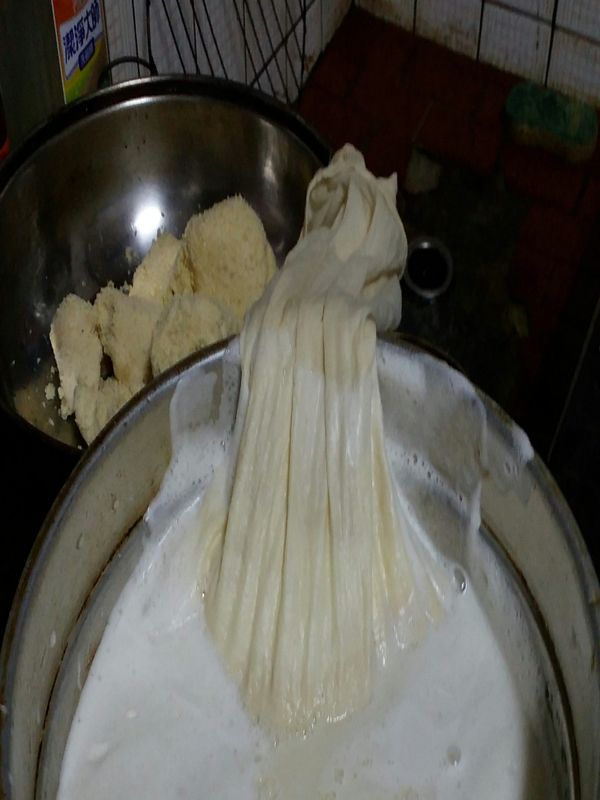 把打好的豆子放入豆漿袋裡捏一捏把豆渣放在另一個鍋子裡