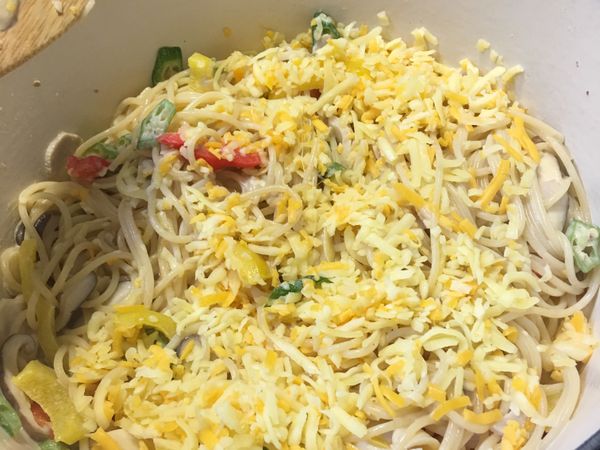 再將麵條拌入，最後灑上乳酪絲