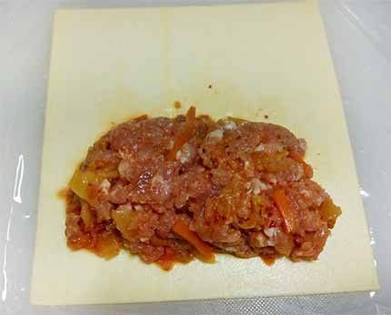 市售起酥皮放室溫軟化後，取約90g內餡放在酥皮一側