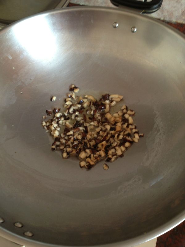 放入一大匙油，放入香菇丁炒香