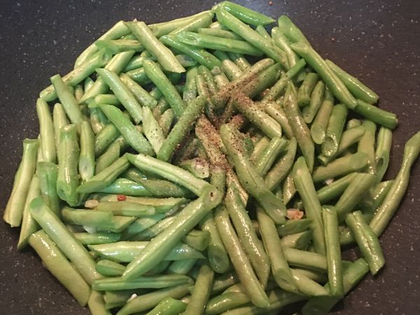 放入四季豆和黑胡椒粉拌炒,