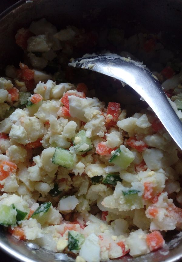 將小黃瓜及水煮蛋置入，煮好放涼的紅蘿蔔丁，馬鈴薯丁中，攪拌，雞蛋可以置入後拌碎也可以切完後再置入。