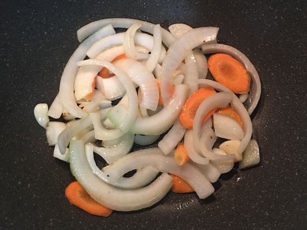 原鍋留ㄧ點油，將蒜和洋蔥炒香後放入紅蘿蔔片拌炒。
