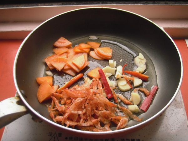 再將櫻花蝦、紅蘿蔔片、辣椒絲、蒜頭片分別放入鍋中約15秒爆香