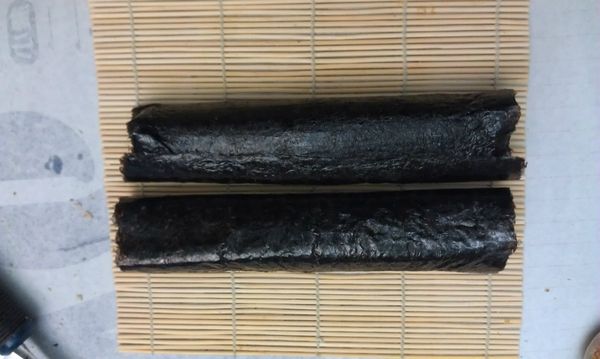 將白飯一碗平舖於一片壽司海苔上，留下最後1/3不要舖上白飯，然後在白飯上撒上肉鬆、海苔香鬆、[菜脯炒洋火腿]、蛋捲、小黃瓜條後，壓緊捲起。