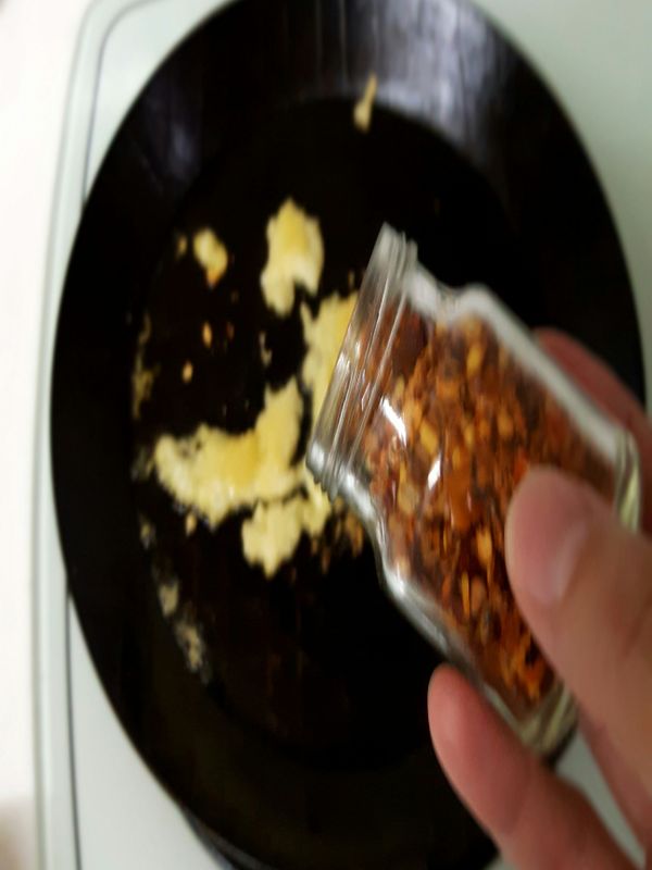 蒜泥香氣出來，下辣椒粒，稍微拌炒後加入四大匙煮麵水