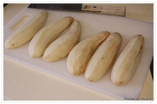 將茄子削皮切成兩半。