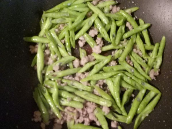 接著丟進四季豆，下半匙鹽巴半匙味精，攪拌均勻！