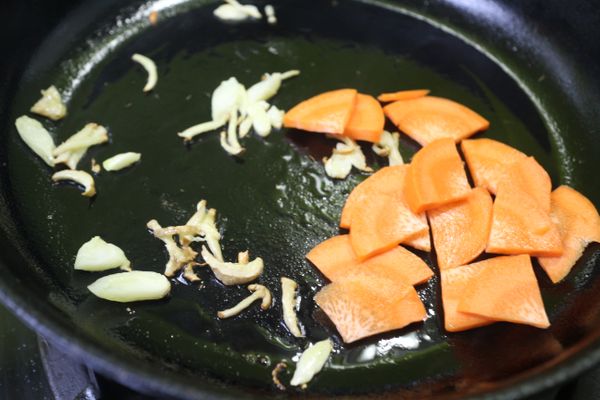 平底鍋加熱,少許的油先炒香蒜末薑絲, 再下紅蘿蔔,(紅蘿蔔是脂溶性的維生素,料理過程要跟油一起炒過才能釋放)