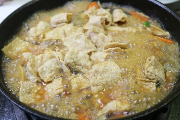 等到魚皮在鍋內漸漸軟了,水也濃縮了,再下泡過水瀝乾的豆皮一起小火繼續滾