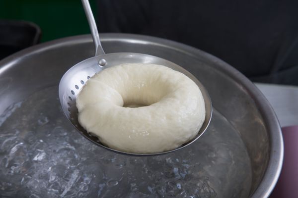 最後發酵完成的麵糰，用煮沸的熱水正反二面各燙10~15秒，撈起稍微瀝乾多餘水份，再放到烤盤上。