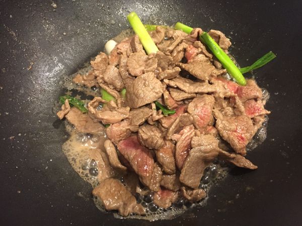 加入牛肉炒至6分熟，加入醬油、鹽巴