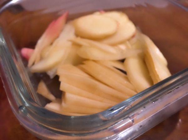 將嫩薑切片，放入容器中。