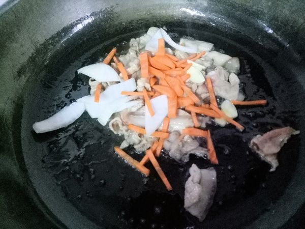 鍋中油熱時，轉小火將肉片或肉絲放入炒至變色。將紅蘿蔔絲、洋蔥與蒜頭放入拌炒。