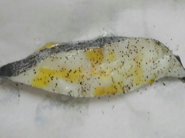 洗去鹽麴。
撕一張烘焙紙（要能將魚包覆起來的大小大小）。
把魚放上去，淋上些米酒、灑上黑胡椒、橄欖油。