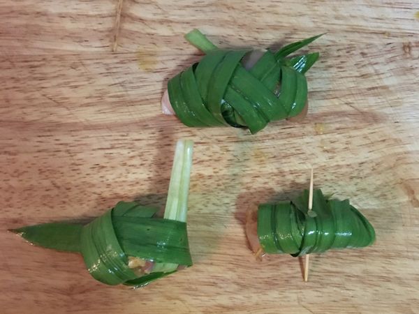 帶手套用洗淨的斑蘭葉，將雞肉包起來，可以用綑綁式纏住雞肉後再用牙籤固定；也可以使用編織的方法，取決於斑蘭葉的大小。