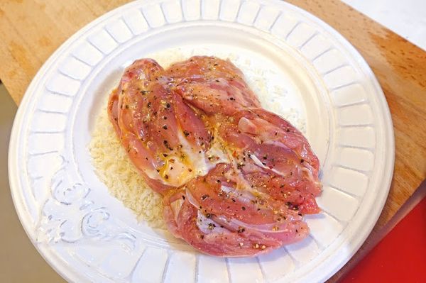 把沾好蛋液的雞腿排兩面滾上麵包粉。