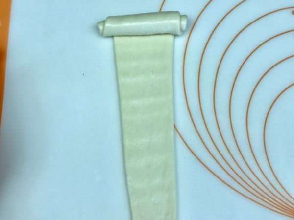 桿長至少20公分以上，由上往下輕輕捲起，尖端收口在下方，整齊排列至烤盤內