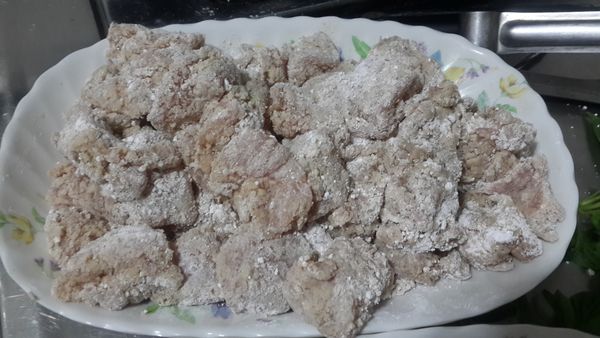 將雞肉一一取出，沾裹上木薯粉後，再放置另一盤子中靜置返潮。