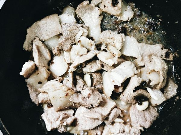 放入豆豉/醬油膏及水續炒，讓五花肉吸收醬汁。