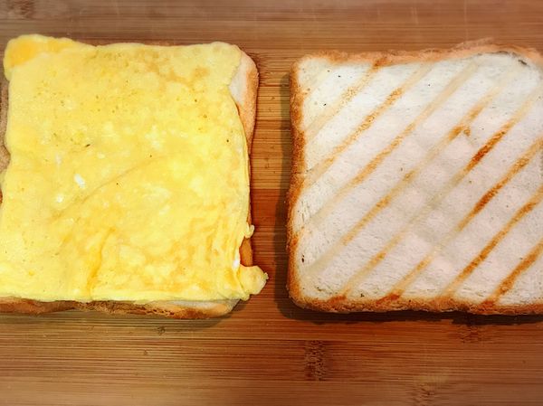 煎好雞蛋，再略煎火腿，然後放在方包上